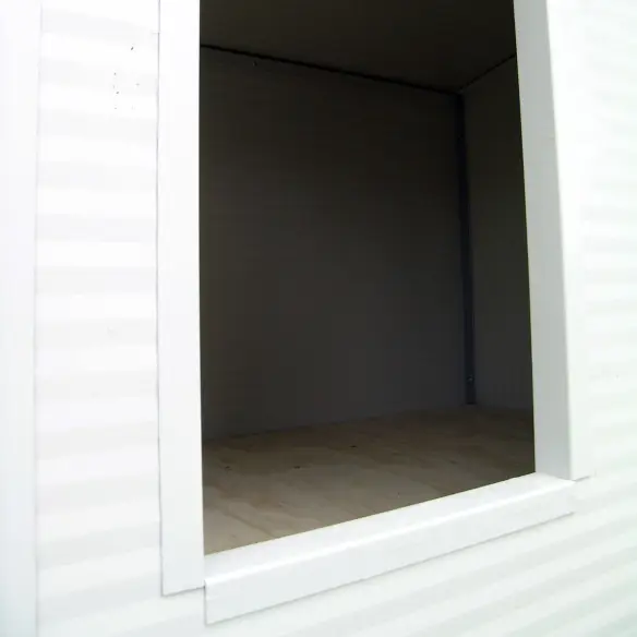 Entrée du chien dans la niche blanche